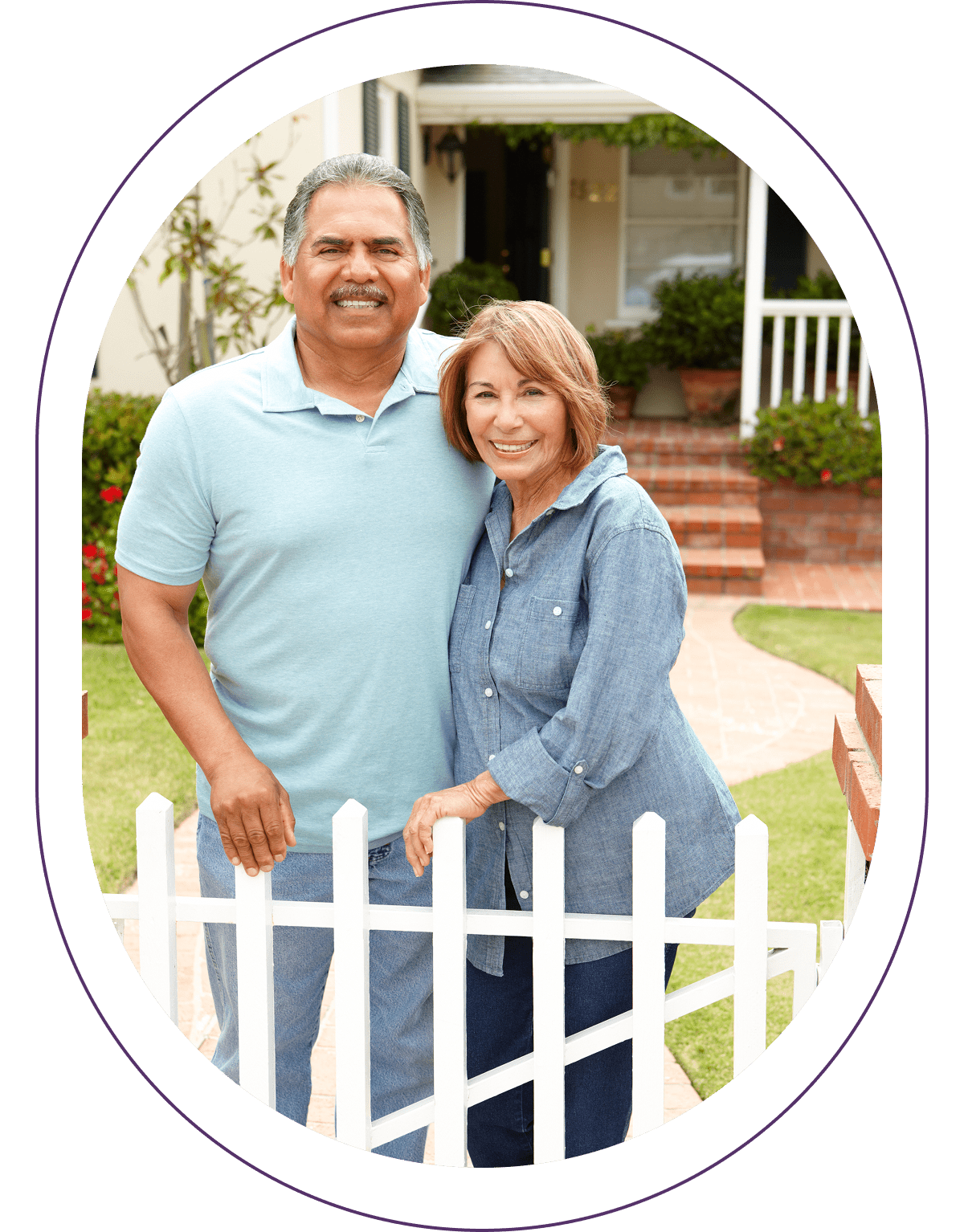 Smiling couple standing by white fence.