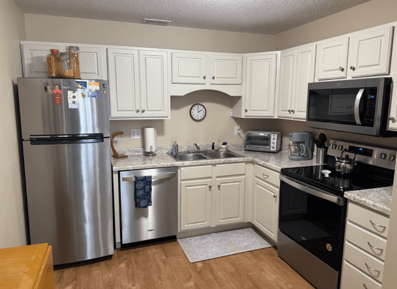 Modern kitchen with white cabinets and appliances.