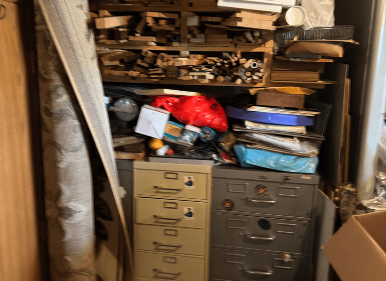 Cluttered storage area with shelves and cabinets.