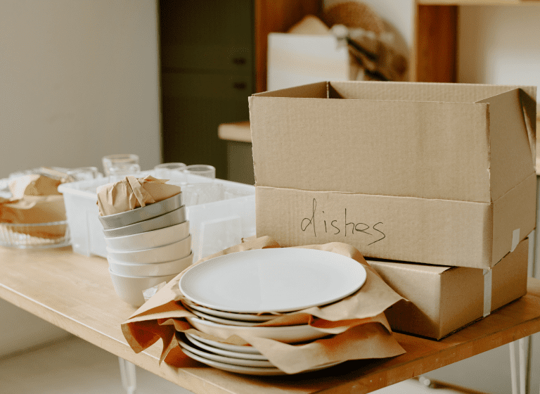 Stacked dishes and boxes on a table.