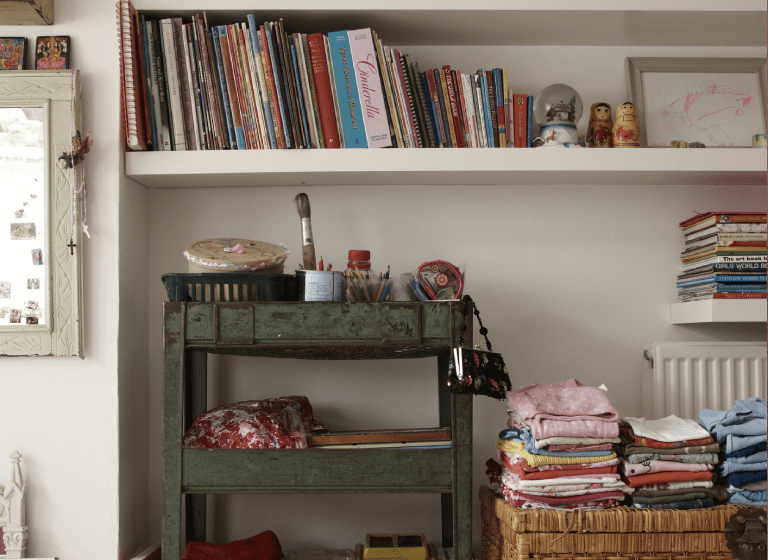 Bookshelf and table with assorted items.