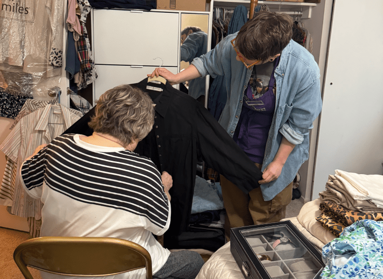 Two people examining a black shirt together.