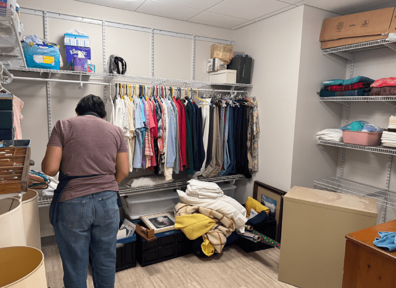 Person organizing clothes in a storage room.