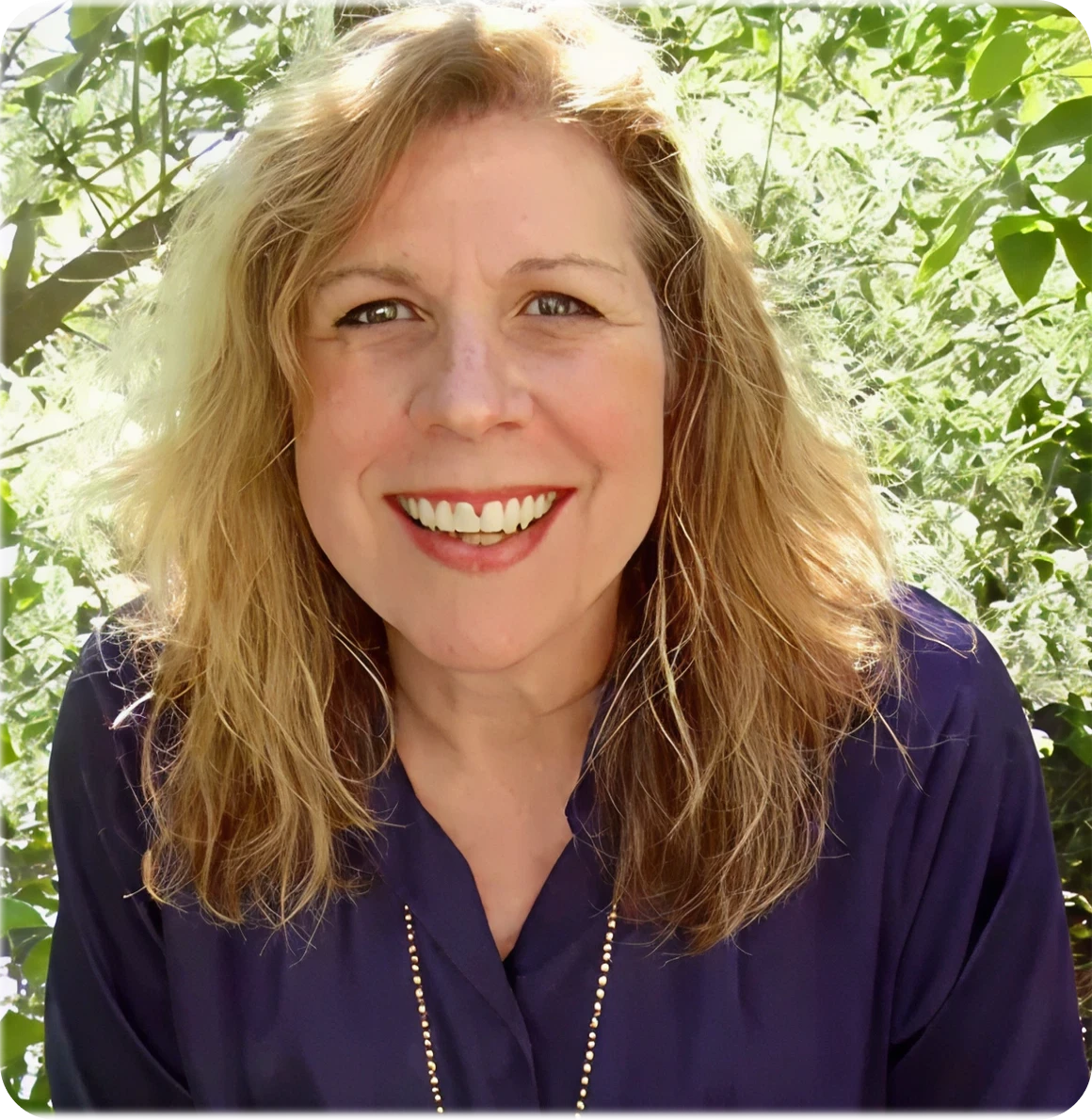 Woman smiling in nature setting.