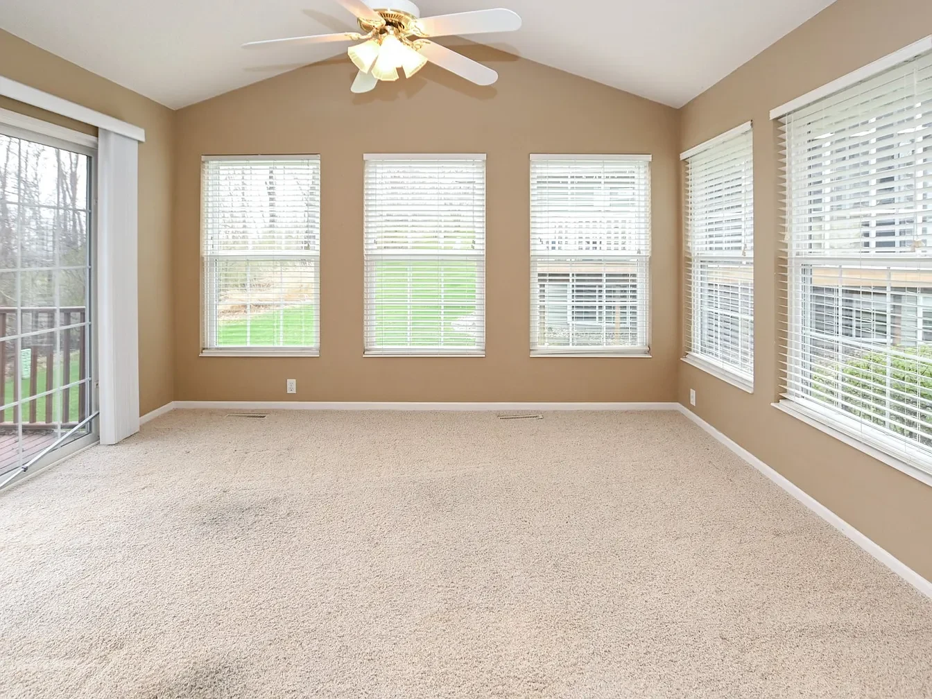 Empty room with windows and beige carpet.