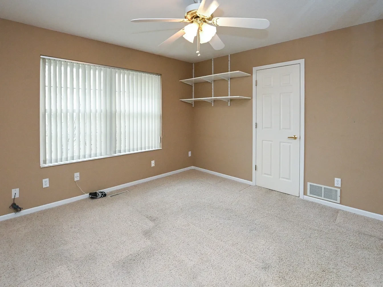 Empty room with beige walls and carpet.
